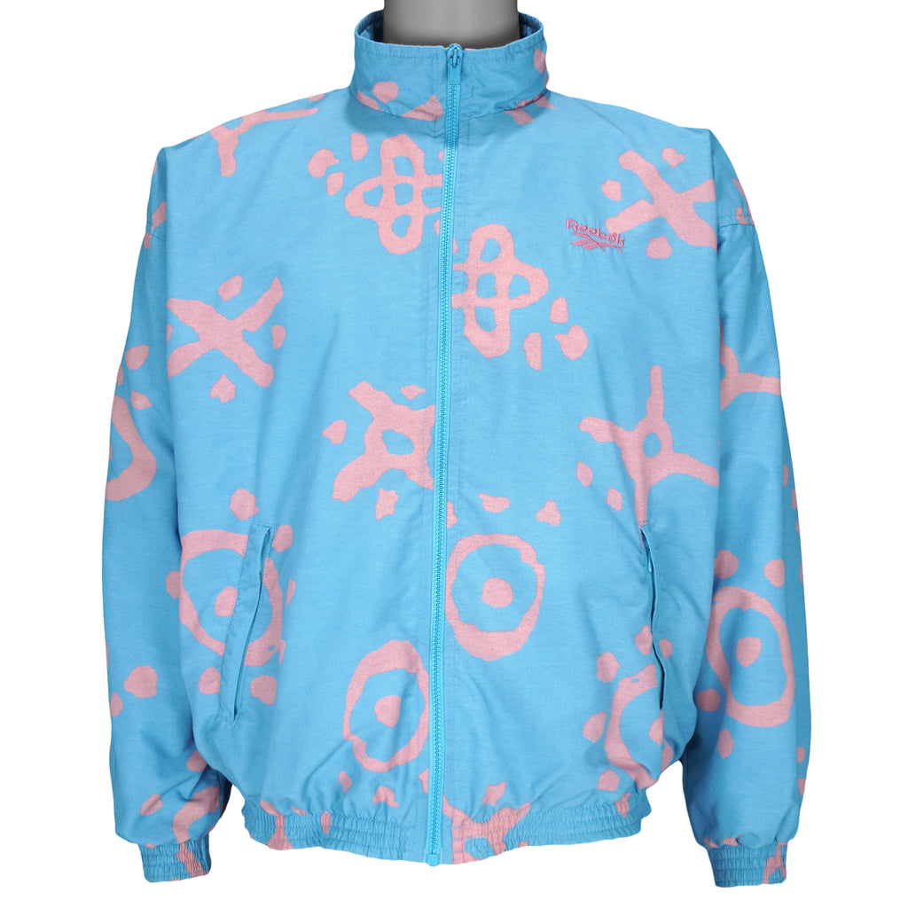 1990s vintage Reebok graffiti-patterned windbreaker. Baby blue in color with pink designs. Fitting Medium in size and in excellent condition.