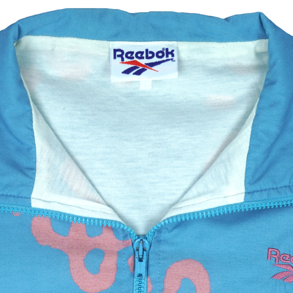 1990s vintage Reebok graffiti-patterned windbreaker. Baby blue in color with pink designs. Fitting Medium in size and in excellent condition.