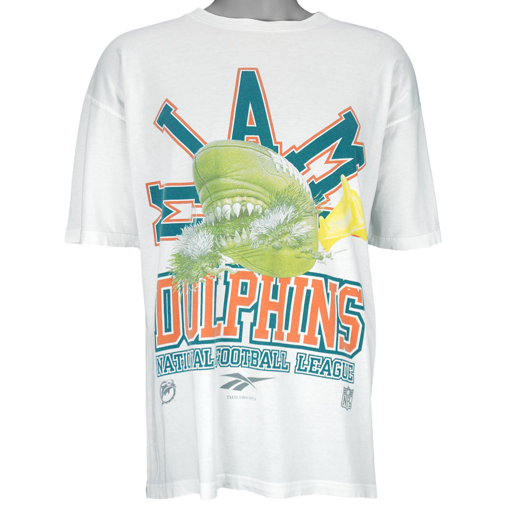 1994 vintage Reebok NFL Miami Dolphins spell-out T-Shirt. White in color with image of a football with teeth on front and Reebok logo on left sleeve, fits X-Large in size and is in excellent condition.