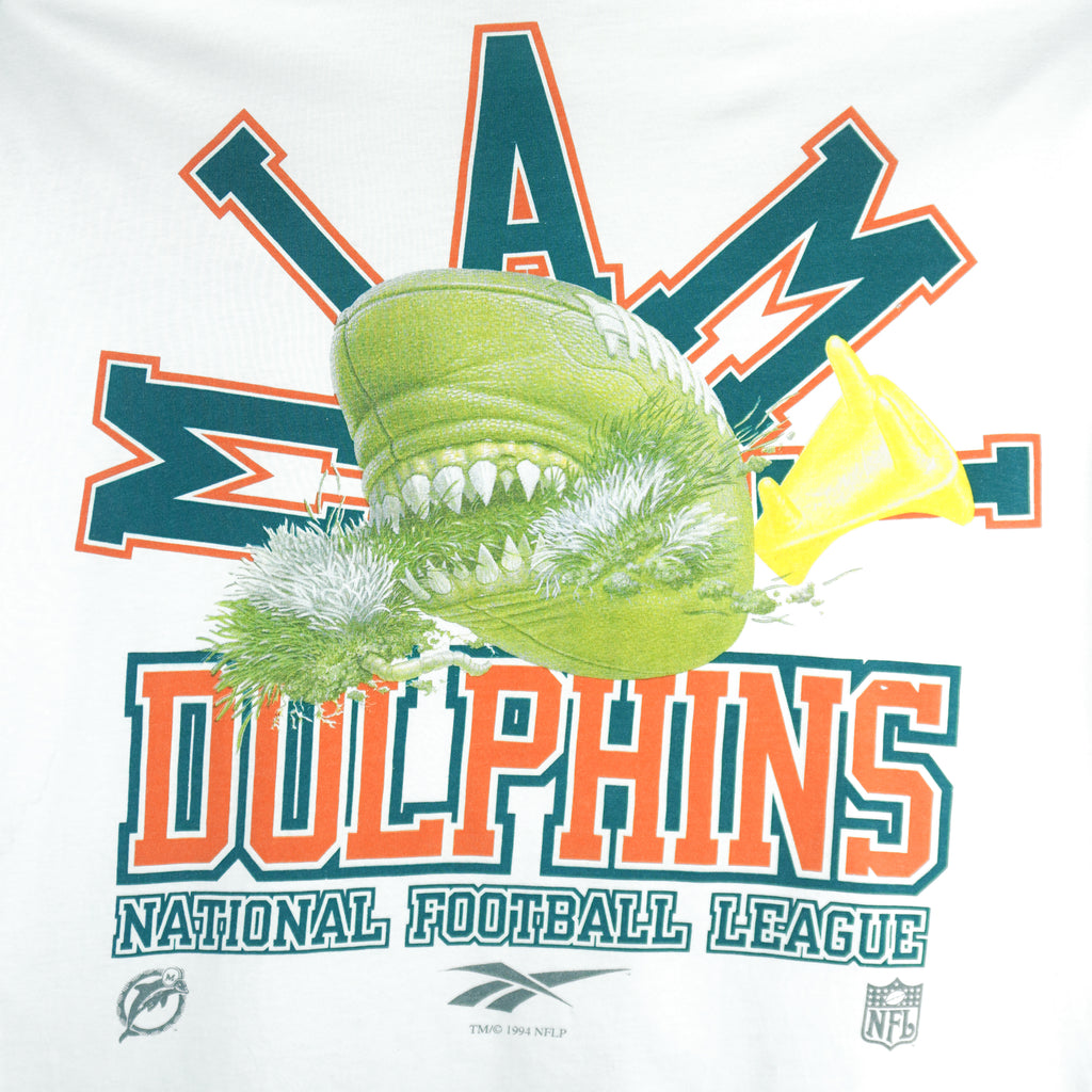 1994 vintage Reebok NFL Miami Dolphins spell-out T-Shirt. White in color with image of a football with teeth on front and Reebok logo on left sleeve, fits X-Large in size and is in excellent condition.