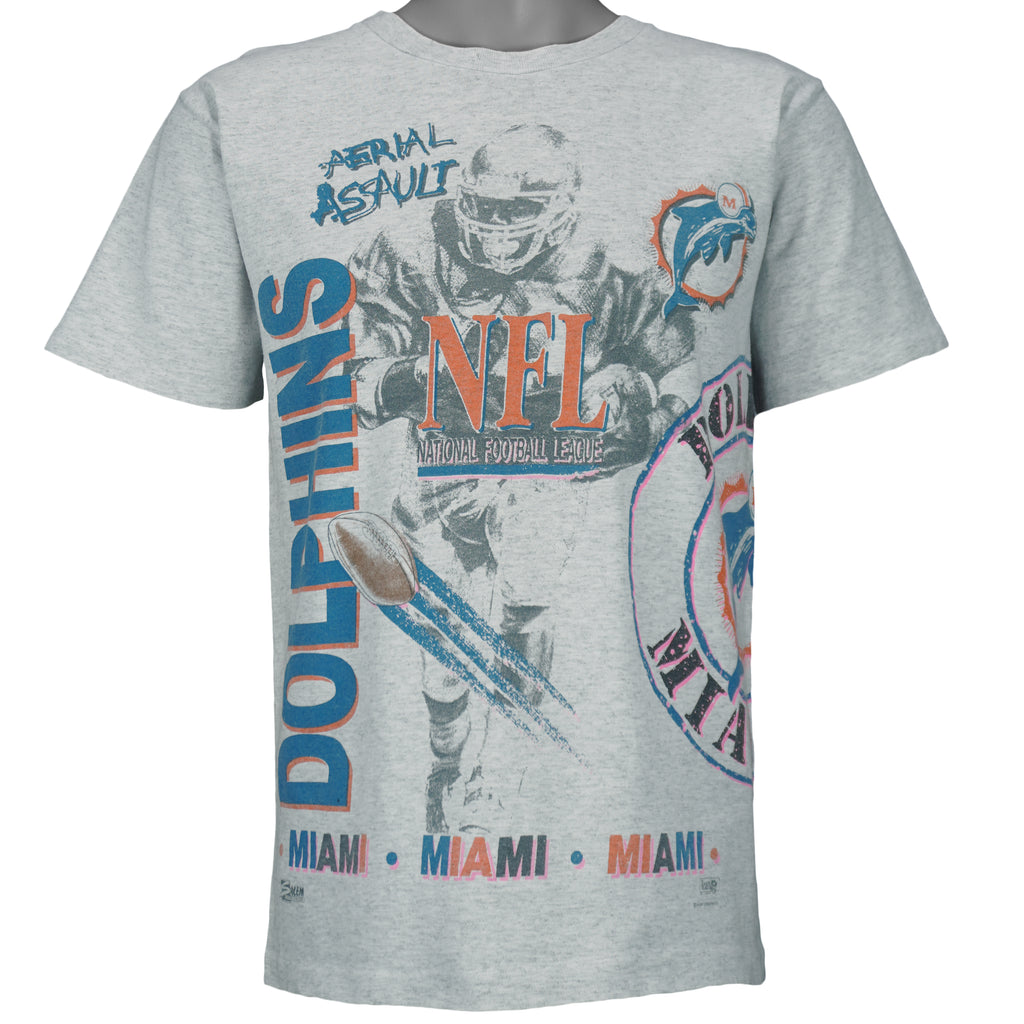 1990 vintage NFL Miami Dolphins, Aerial Assault, all-over-print T-Shirt by Salem Sportswear. Grey in color, fits Medium in size and is in excellent condition.