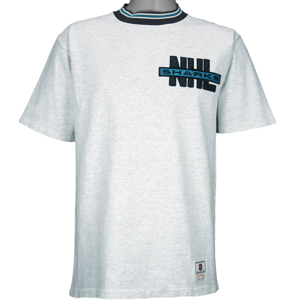 1990s vintage NHL San Jose Sharks embroidered T-Shirt by Nutmeg Mills. Grey in color with black and teal collar, fits Large in size and is in excellent condition.