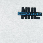 1990s vintage NHL San Jose Sharks embroidered T-Shirt by Nutmeg Mills. Grey in color with black and teal collar, fits Large in size and is in excellent condition.