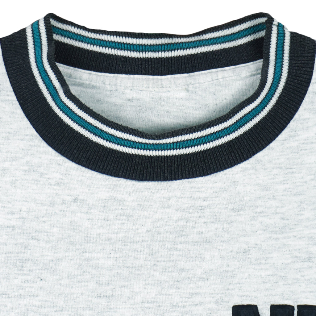 1990s vintage NHL San Jose Sharks embroidered T-Shirt by Nutmeg Mills. Grey in color with black and teal collar, fits Large in size and is in excellent condition.