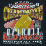 1998 vintage NHL Detroit Red Wings Stanley Cup Champions 97-98 T-Shirt by Logo 7. Black in color with big printed graphic and spell-out on front: Cup 2 Cup, Nine for All Time. Large in size and is in excellent condition.