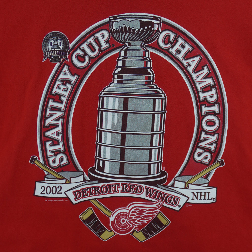 2002 vintage NHL Detroit Red Wings Stanley Cup Champions Big Logo T-Shirt by CSA. Red in color with spell-out and trophy graphic on front by VF Imagewear. Fits Large in size and in excellent condition.