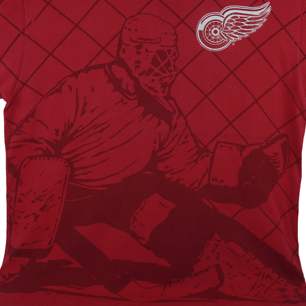 1990s vintage NHL Detroit Red Wings all over print T-Shirt. Red in color with goalie and net silhouette, and team logo on front. Fits X-Large size and in excellent condition.