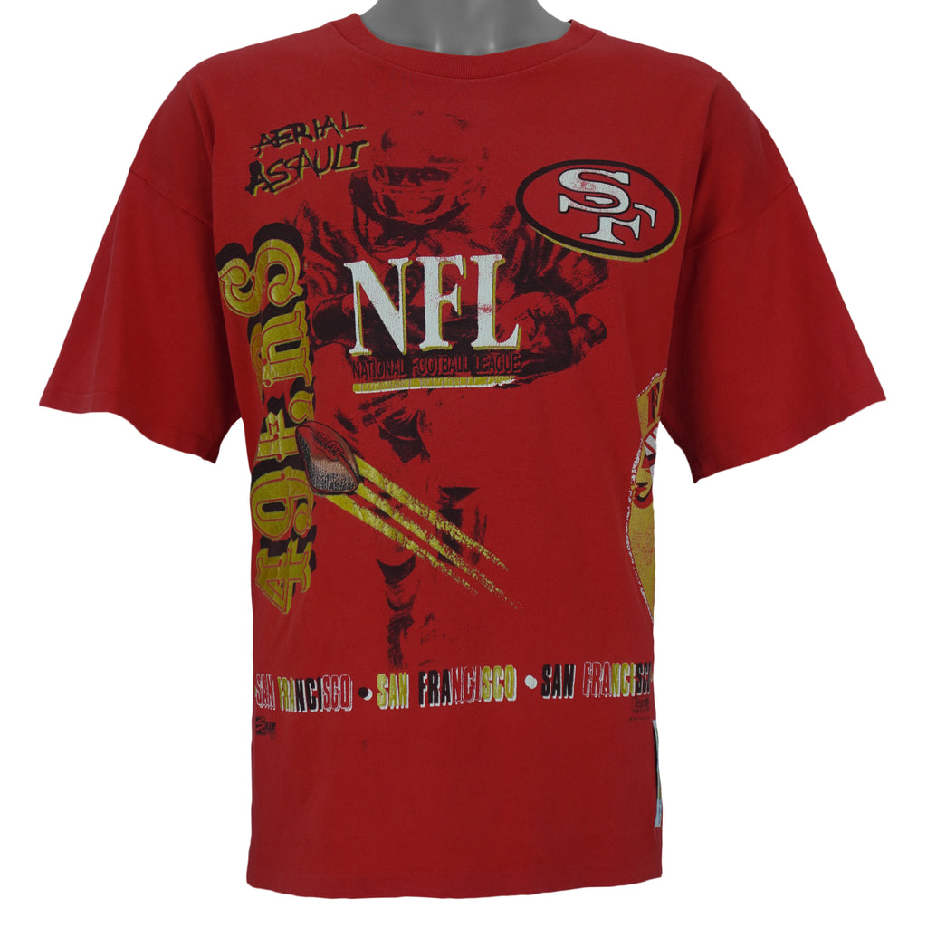 1990s vintage NFL San Francisco 49ers Aerial Assault all over print T-Shirt by Salem Sportswear. Red in color with spell-out and big logos, Salem patch on lower left front, is X-Large in size and is in excellent condition.