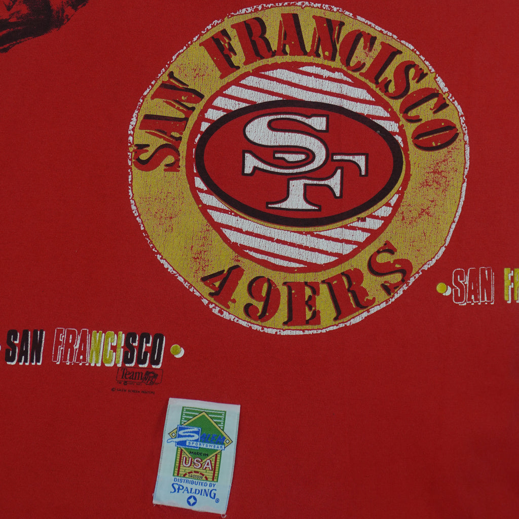 1990s vintage NFL San Francisco 49ers Aerial Assault all over print T-Shirt by Salem Sportswear. Red in color with spell-out and big logos, Salem patch on lower left front, is X-Large in size and is in excellent condition.