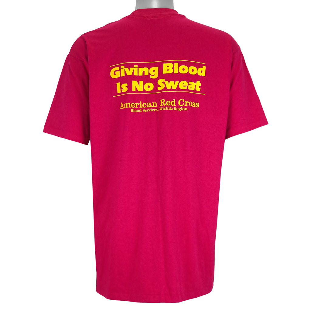 1990 vintage American Red Cross Blood Run, Wichita region, T-Shirt by Hanes. Pink in color with printed graphics on front and back, tagged size X-Large, and is in excellent condition.