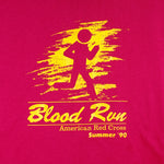 1990 vintage American Red Cross Blood Run, Wichita region, T-Shirt by Hanes. Pink in color with printed graphics on front and back, tagged size X-Large, and is in excellent condition.